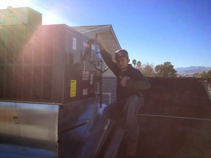 HVAC technician performing Heat Pump Repair on a rooftop unit in Guymon